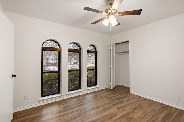 unfurnished bedroom featuring ceiling fan and dark hardwood / wood-style floors