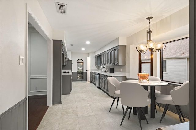 kitchen featuring gray cabinets, light tile patterned floors, dishwasher, and an inviting chandelier