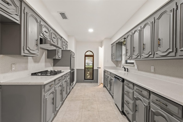 kitchen with sink, light tile patterned flooring, stainless steel appliances, and tasteful backsplash