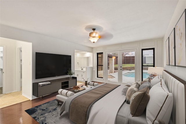 bedroom with french doors, wood-type flooring, and access to outside