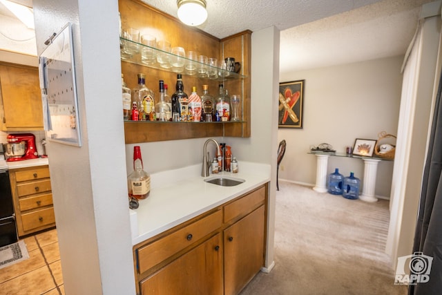 bar featuring light tile patterned floors, sink, and a textured ceiling