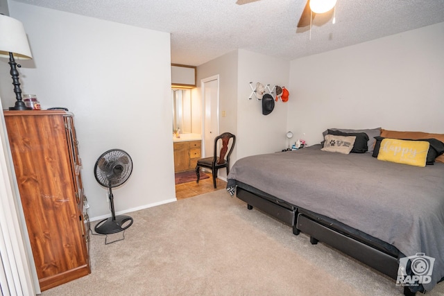 bedroom featuring a textured ceiling, light colored carpet, and ceiling fan