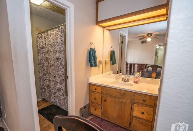 bathroom with curtained shower, vanity, a textured ceiling, ceiling fan, and tile patterned flooring