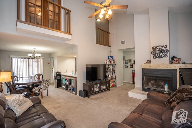 carpeted living room featuring ceiling fan with notable chandelier