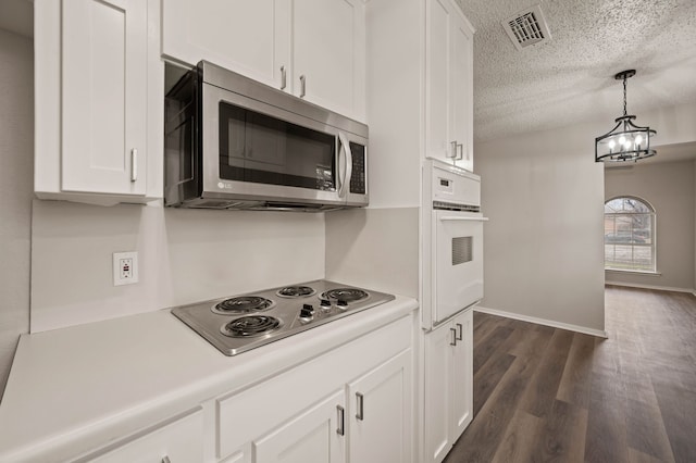 kitchen with oven, visible vents, light countertops, stainless steel microwave, and cooktop