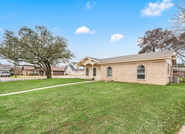 ranch-style house featuring brick siding, central AC, and a front lawn