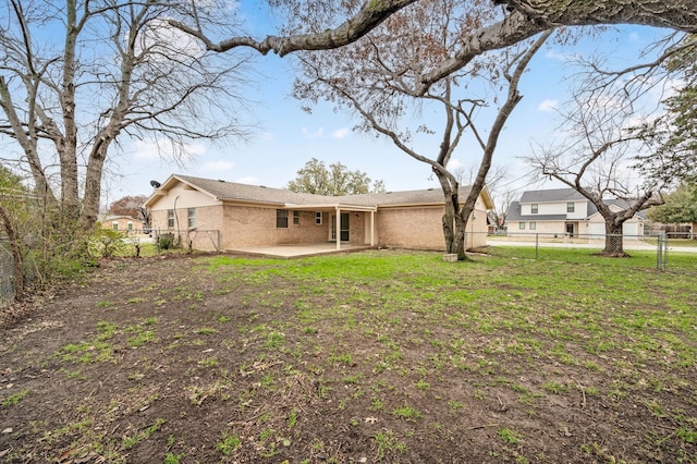 back of property featuring a patio area, a fenced backyard, a lawn, and brick siding