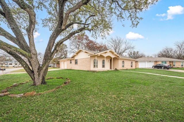 single story home with a front lawn, an attached garage, and stucco siding