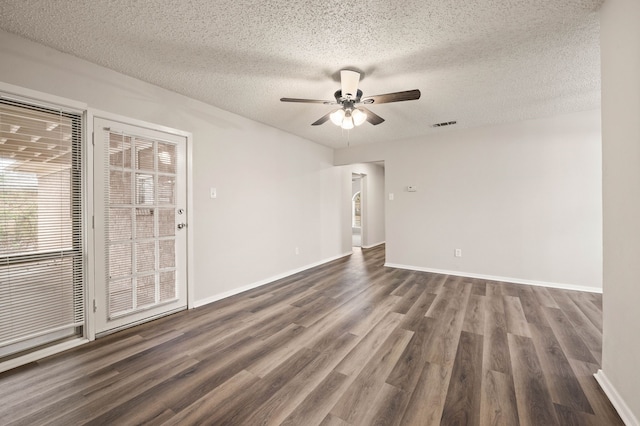 spare room with ceiling fan, a textured ceiling, baseboards, and dark wood-type flooring