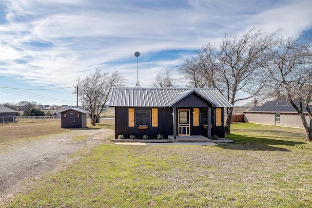 view of front facade featuring a storage unit and a front yard