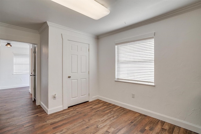 unfurnished bedroom featuring crown molding and dark hardwood / wood-style floors