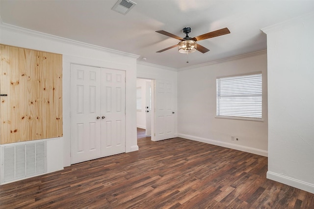 unfurnished bedroom with ceiling fan, a closet, crown molding, and dark hardwood / wood-style flooring