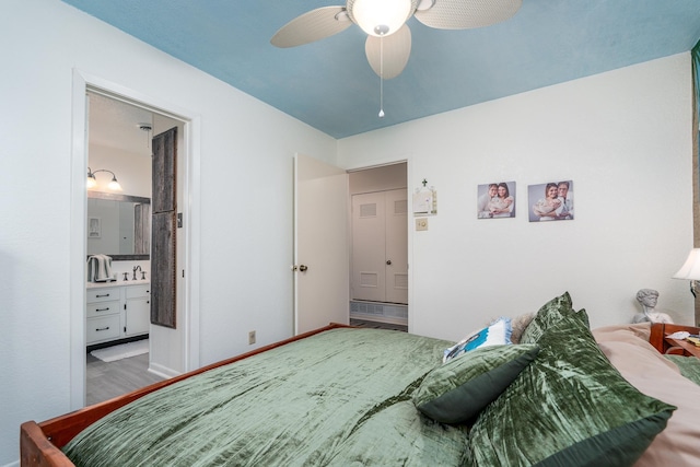 bedroom featuring sink, hardwood / wood-style flooring, connected bathroom, and ceiling fan