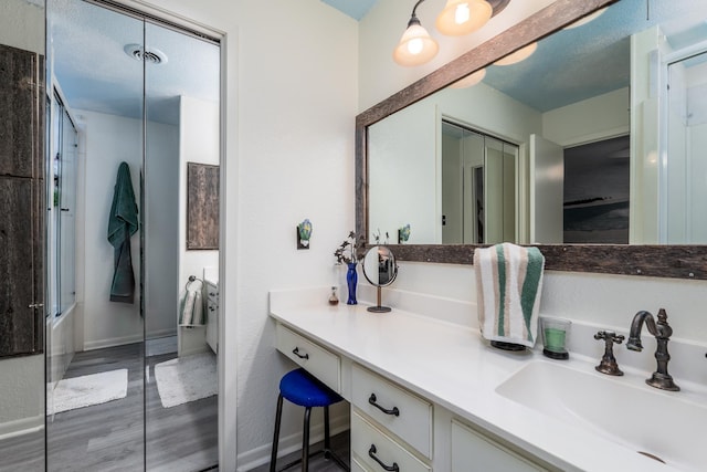 bathroom featuring vanity and combined bath / shower with glass door