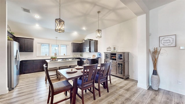 dining room with light hardwood / wood-style floors and lofted ceiling