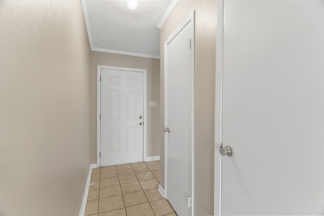 corridor with a textured ceiling, crown molding, and light tile patterned floors