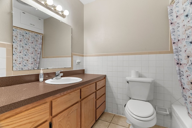 bathroom with toilet, tile patterned flooring, tile walls, and vanity