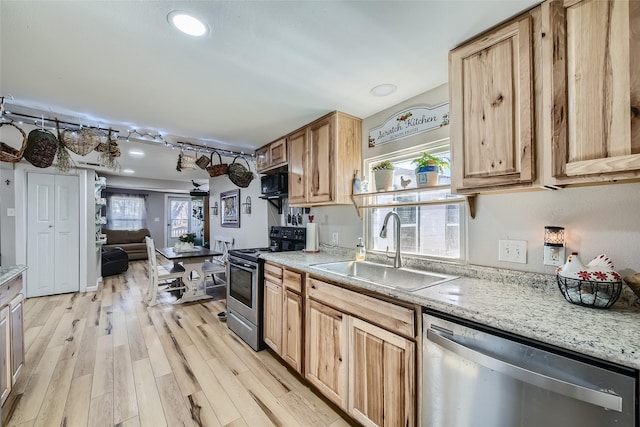 kitchen featuring sink, light wood-type flooring, stainless steel appliances, light brown cabinetry, and light stone countertops