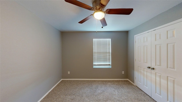 unfurnished bedroom featuring light carpet, ceiling fan, baseboards, and a closet