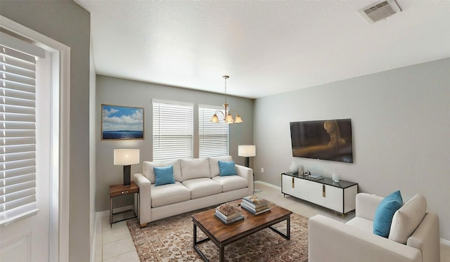 living room with baseboards, visible vents, an inviting chandelier, a textured ceiling, and light tile patterned flooring