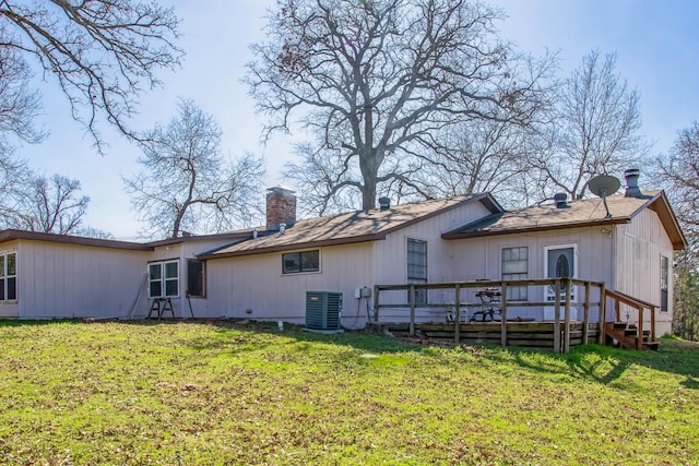 rear view of property featuring a deck, central air condition unit, and a lawn