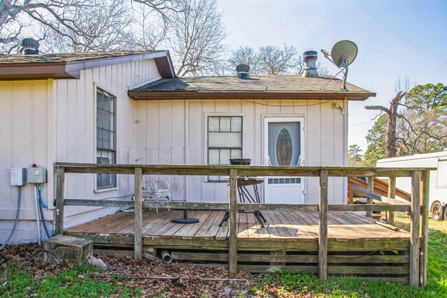 rear view of house featuring a wooden deck