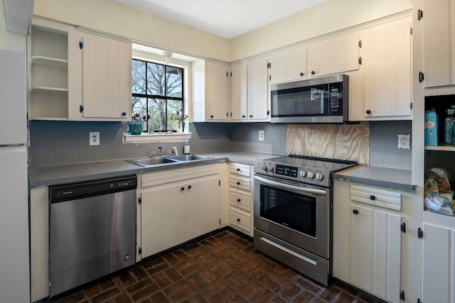 kitchen with white cabinets, stainless steel appliances, tasteful backsplash, and sink