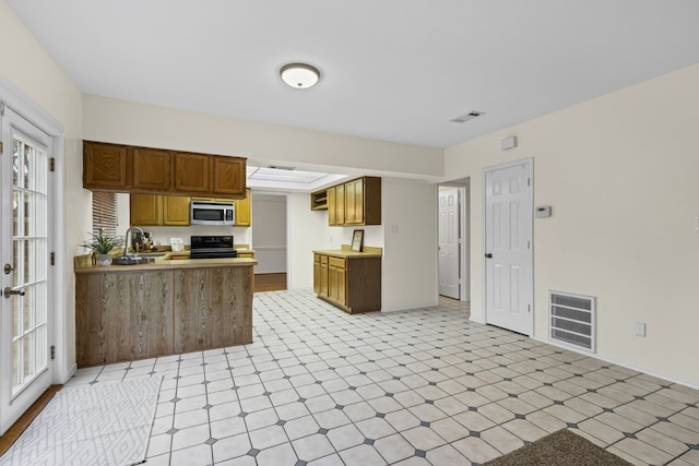 kitchen with sink, electric range oven, and kitchen peninsula