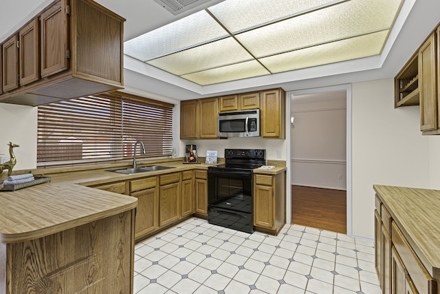 kitchen featuring black electric range, sink, and kitchen peninsula