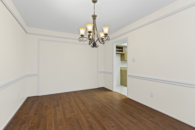 spare room featuring dark hardwood / wood-style floors and a notable chandelier