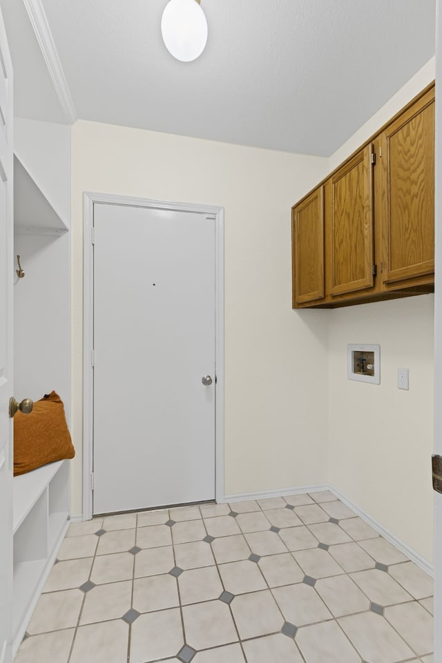 laundry room with washer hookup, crown molding, and cabinets