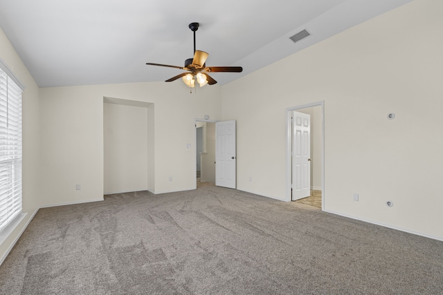 carpeted empty room with vaulted ceiling and ceiling fan