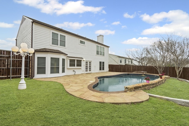 rear view of house featuring a lawn, a fenced in pool, and a patio area