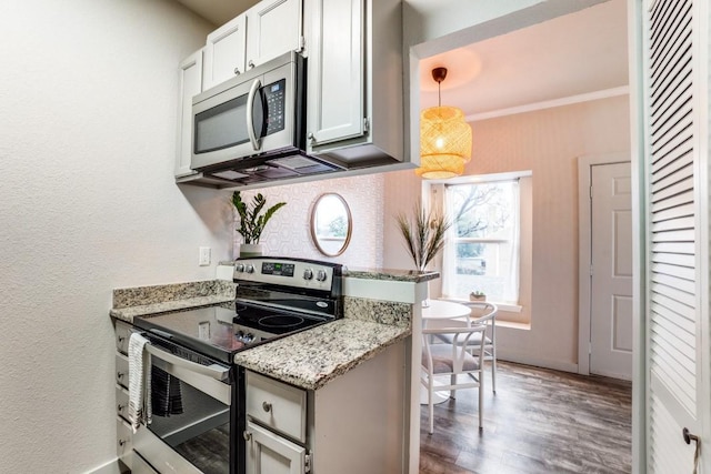 kitchen with hanging light fixtures, stainless steel appliances, light stone countertops, crown molding, and white cabinetry