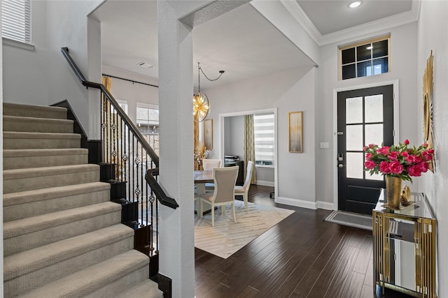 foyer featuring a notable chandelier, dark hardwood / wood-style floors, and ornamental molding