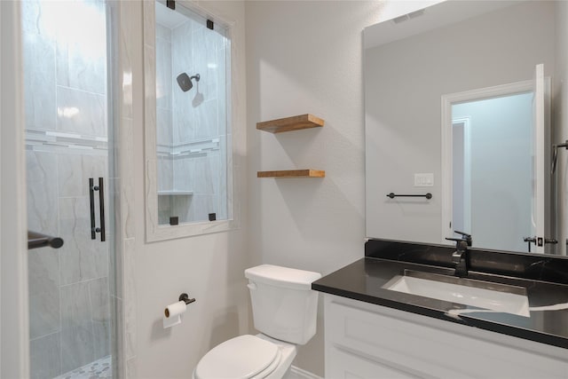 bathroom featuring toilet, vanity, and walk in shower