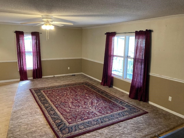 unfurnished room featuring a healthy amount of sunlight, ceiling fan, and a textured ceiling