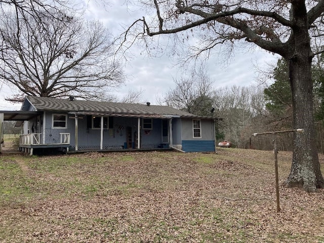 rear view of property featuring covered porch