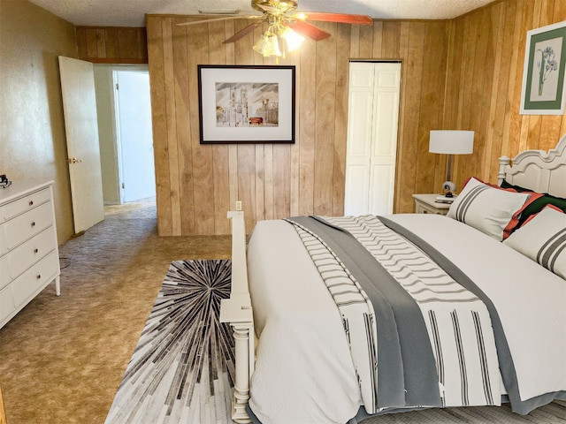 bedroom with carpet floors, a closet, and wood walls