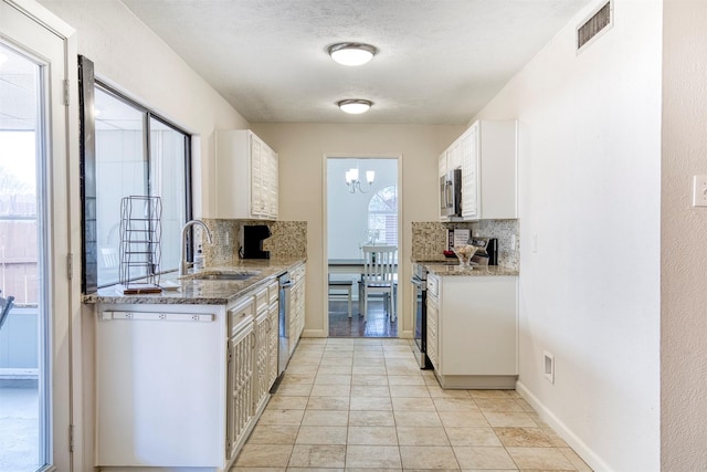 kitchen featuring appliances with stainless steel finishes, light stone countertops, visible vents, and white cabinets