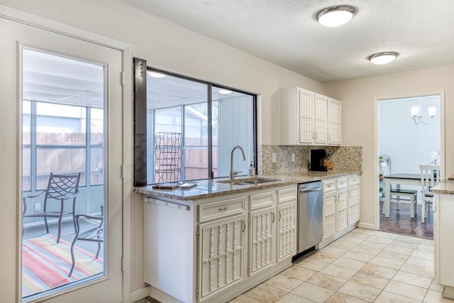 kitchen featuring dishwasher, plenty of natural light, white cabinets, and a sink