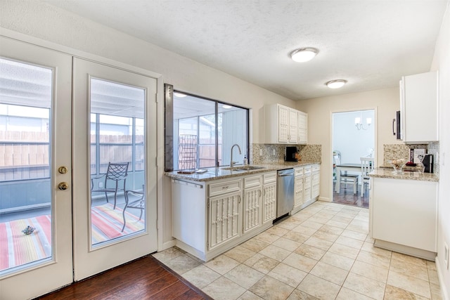 kitchen featuring light stone counters, white cabinets, appliances with stainless steel finishes, and decorative backsplash