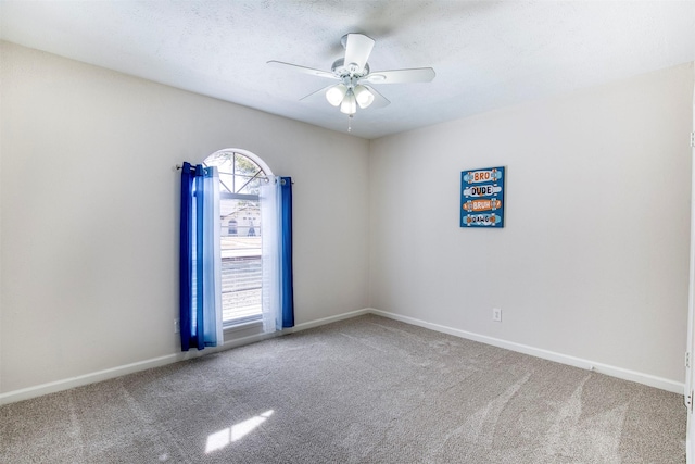 spare room with carpet flooring, ceiling fan, a textured ceiling, and baseboards