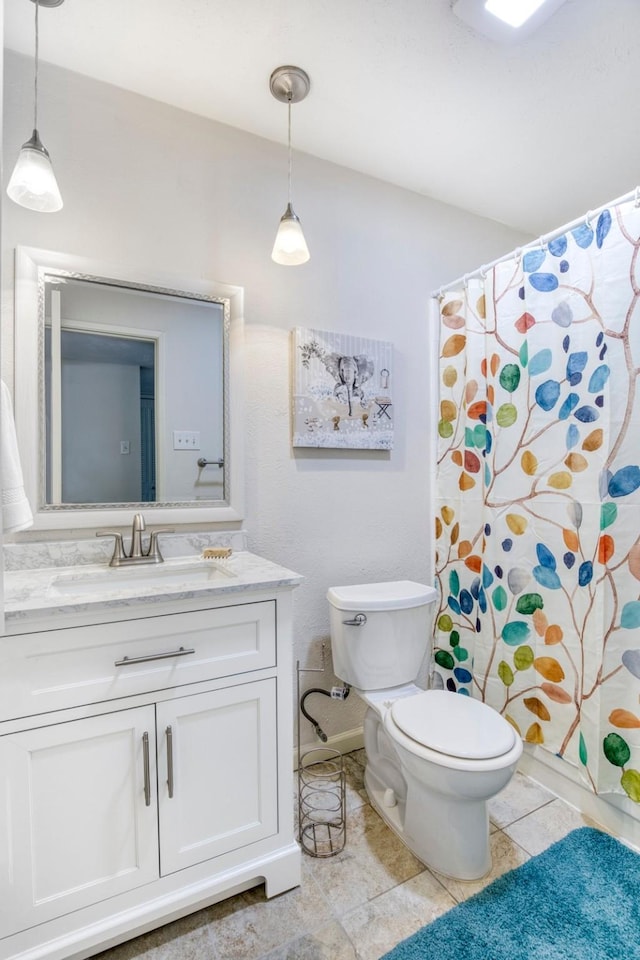 full bathroom featuring toilet, vanity, and tile patterned floors