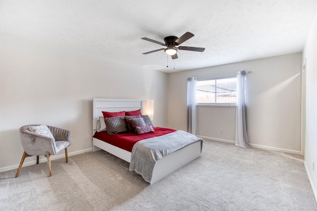 bedroom featuring a ceiling fan, baseboards, a textured ceiling, and light colored carpet