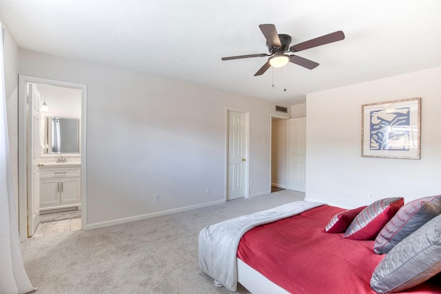 bedroom featuring light colored carpet, visible vents, connected bathroom, a sink, and baseboards