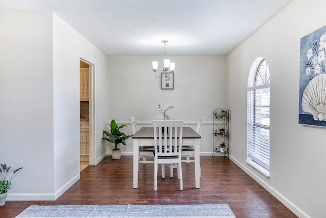 dining space featuring baseboards, dark wood-style flooring, and an inviting chandelier