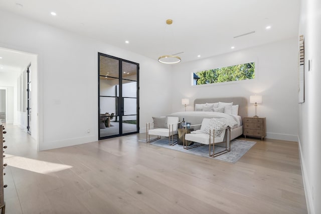 bedroom with light wood-type flooring and french doors