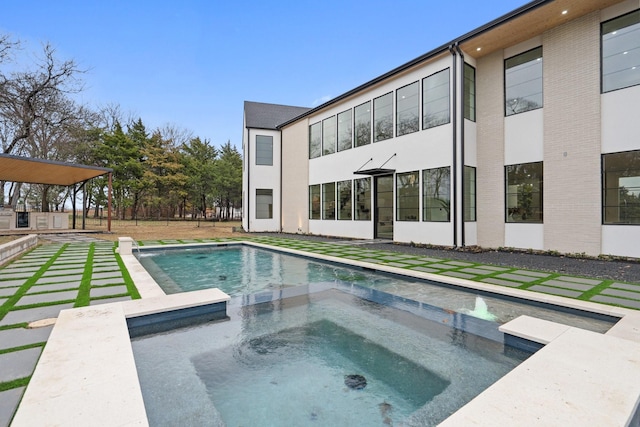 view of pool with an in ground hot tub