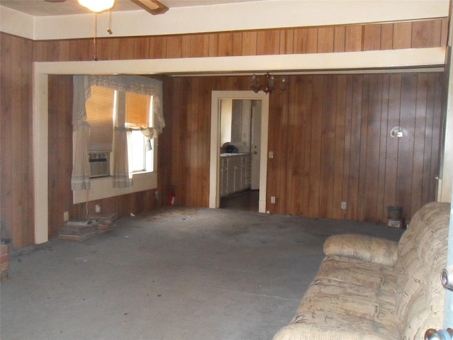 unfurnished living room with wood walls and ceiling fan